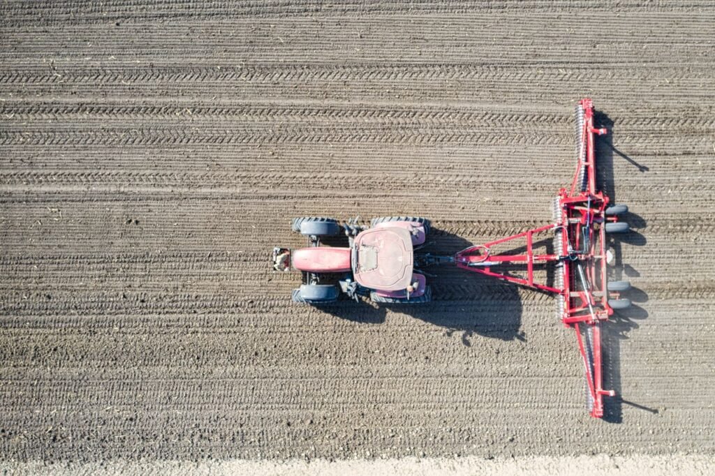 Drone shot of a tractor plowing an agricultural field in Minnesota, USA.