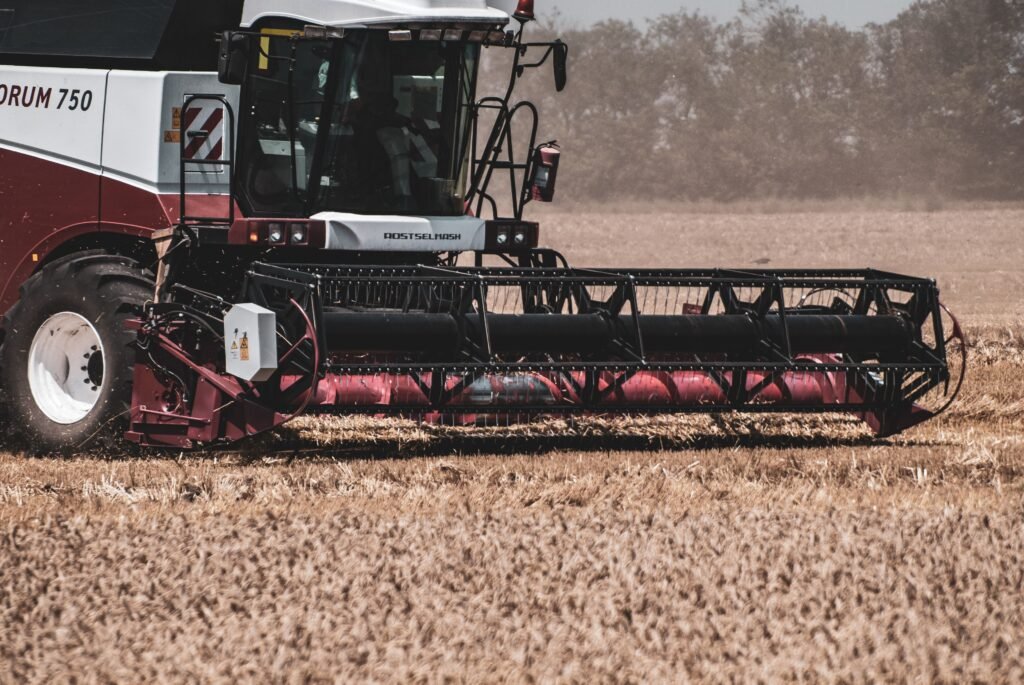 Combine harvester working in a wheat field during daytime, showcasing modern agricultural machinery.